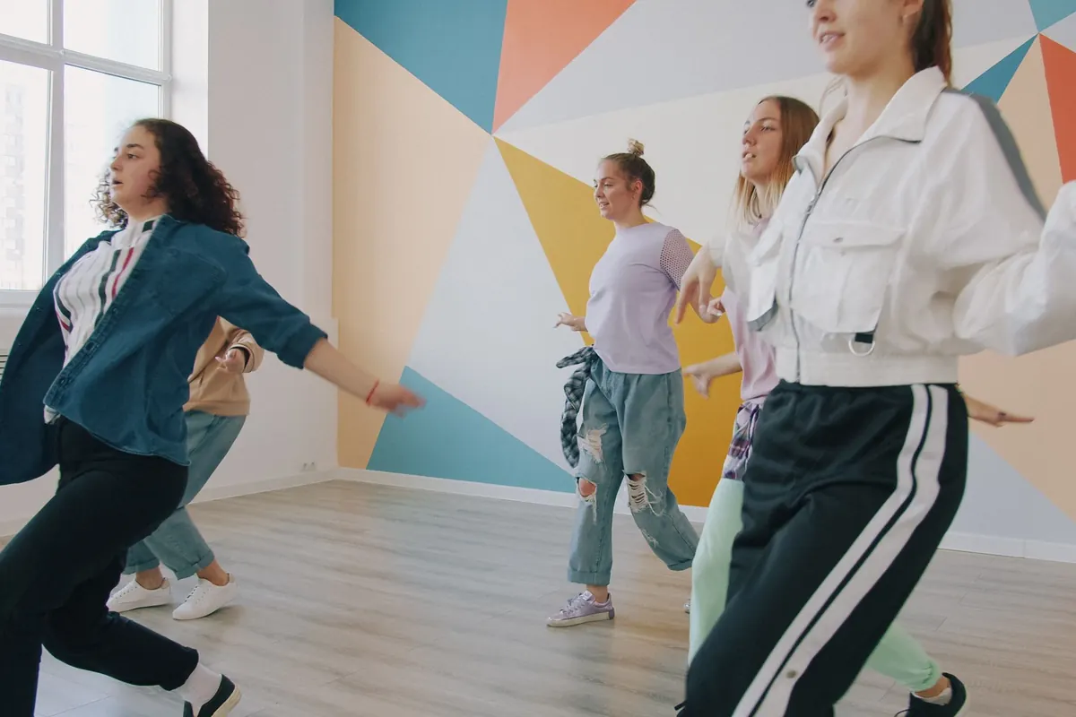 Gruppe tanzt fröhlich in einem hellen Tanzstudio