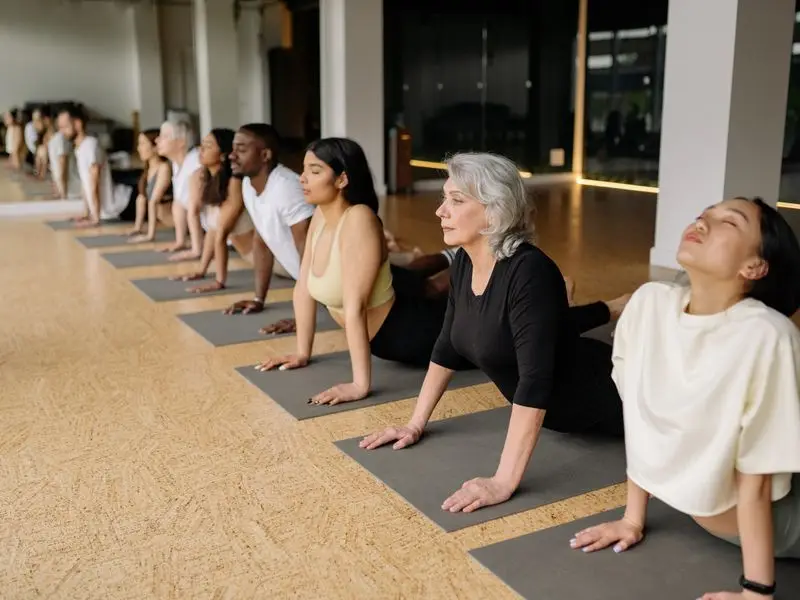 Yogagruppe auf Matten in einem hellen Kursraum